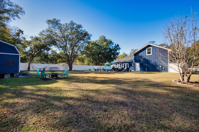 view of yard with a shed and an outdoor fire pit