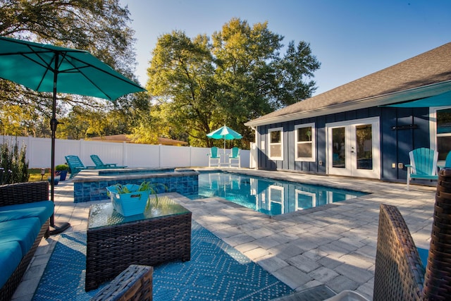 view of pool with an outdoor living space, a patio area, an in ground hot tub, and french doors