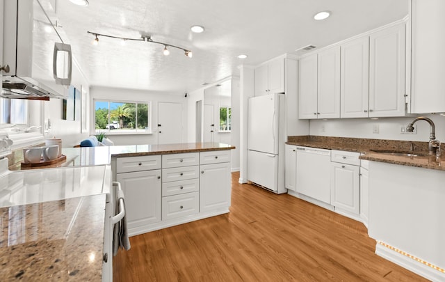 kitchen featuring visible vents, light wood-type flooring, white cabinets, white appliances, and a sink