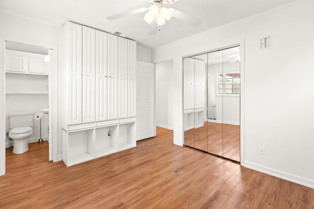 unfurnished bedroom featuring ceiling fan, light wood-type flooring, and ensuite bath