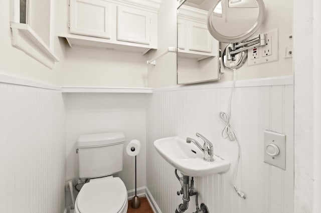 bathroom with a wainscoted wall and toilet