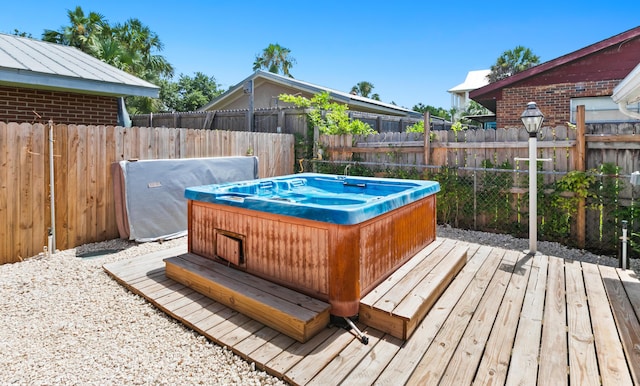 wooden terrace featuring fence, area for grilling, and a hot tub