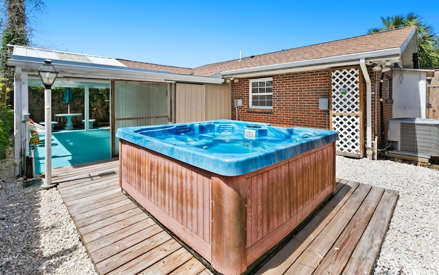 wooden terrace with cooling unit and a hot tub