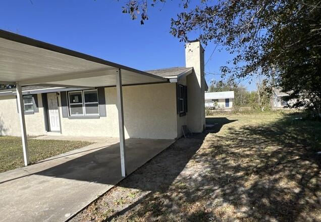 view of side of home with a carport