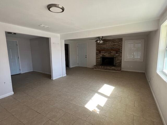 unfurnished living room with ceiling fan and a fireplace