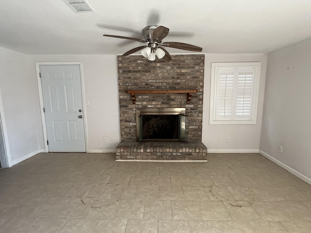 unfurnished living room featuring ceiling fan and a brick fireplace