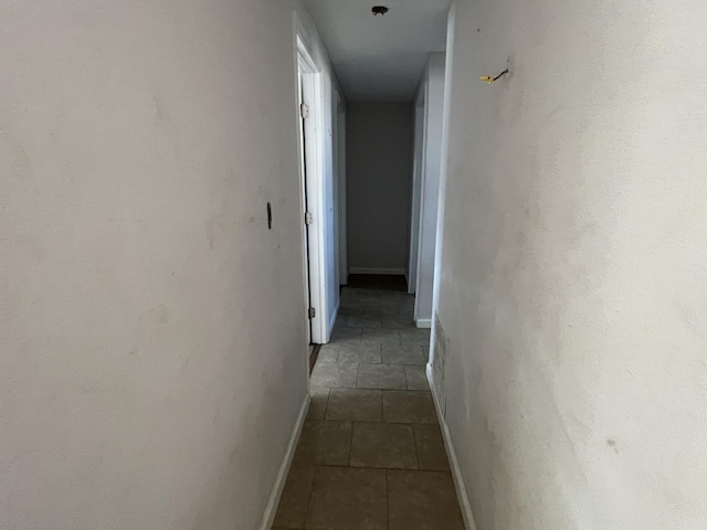 hallway featuring dark tile patterned floors