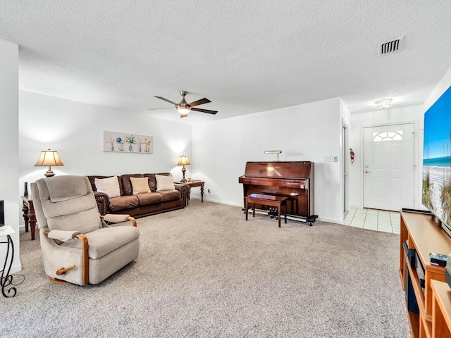 living room featuring ceiling fan, carpet floors, and a textured ceiling