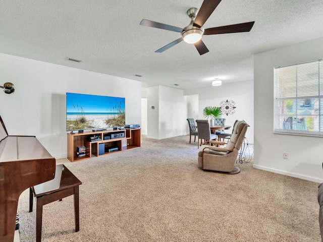 living room with carpet flooring, ceiling fan, and a textured ceiling