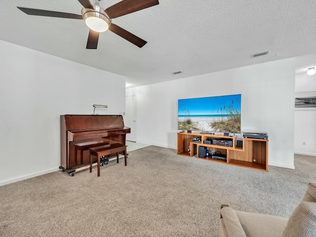 living room featuring ceiling fan, carpet floors, and a textured ceiling