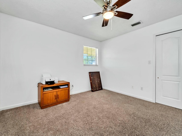 carpeted spare room featuring ceiling fan