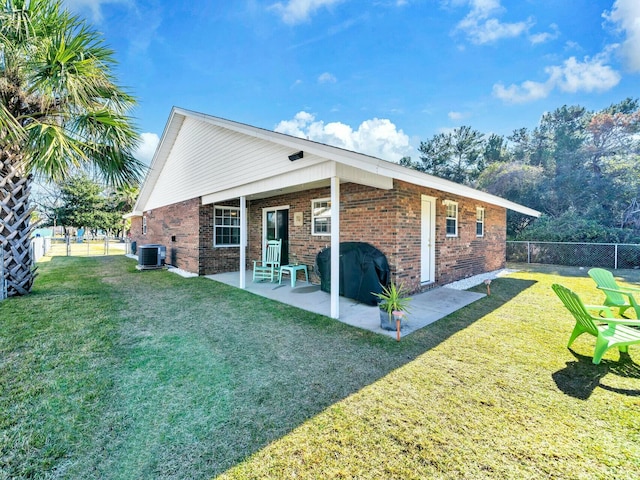 back of property with a yard, a patio area, and central air condition unit