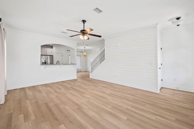 258 Tropical Breeze Dr, Santa Rosa Beach, FL 32459 - unfurnished living room with ceiling fan, light wood-type flooring, arched walkways, and crown molding