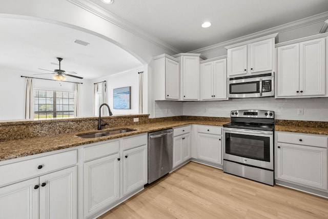 258 Tropical Breeze Dr, Santa Rosa Beach, FL 32459 - kitchen featuring appliances with stainless steel finishes, white cabinets, crown molding, a ceiling fan, and dark stone countertops