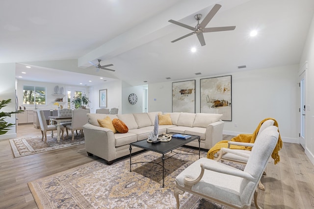 living room featuring ceiling fan, light wood-type flooring, and vaulted ceiling with beams