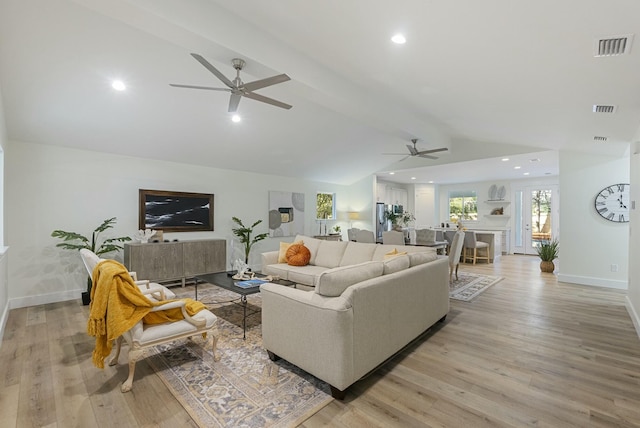 living room featuring a fireplace, lofted ceiling with beams, ceiling fan, and light wood-type flooring