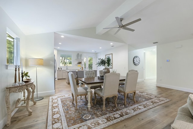 dining room featuring ceiling fan, light hardwood / wood-style flooring, and vaulted ceiling with beams