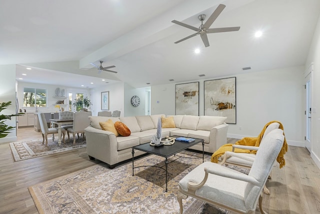 living room with lofted ceiling with beams, ceiling fan, and light hardwood / wood-style flooring