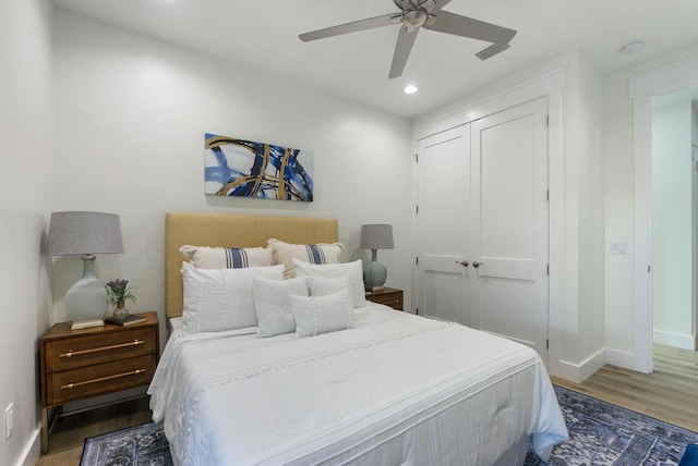 bedroom with ceiling fan, a closet, and dark hardwood / wood-style floors