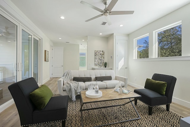 living room featuring french doors, light wood-type flooring, and ceiling fan