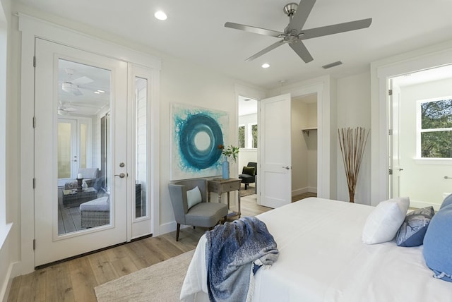 bedroom featuring french doors, ceiling fan, light hardwood / wood-style flooring, and multiple windows