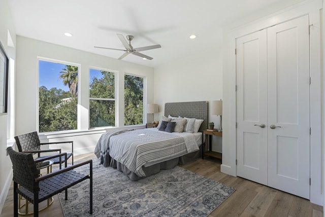 bedroom with dark hardwood / wood-style flooring, a closet, and ceiling fan