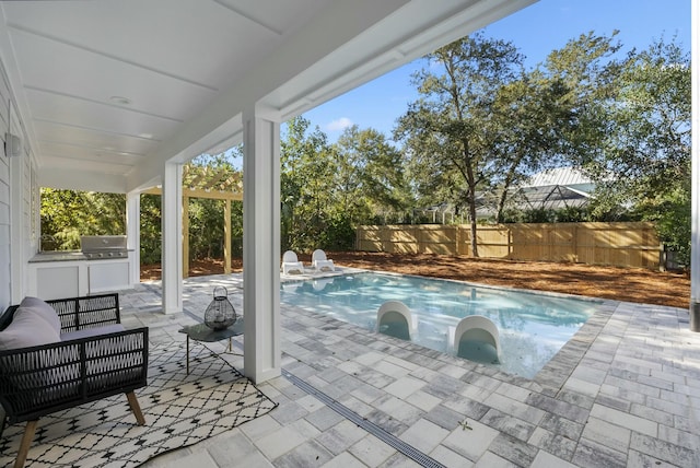 view of swimming pool with an outdoor kitchen, a patio area, an outdoor living space, and a grill