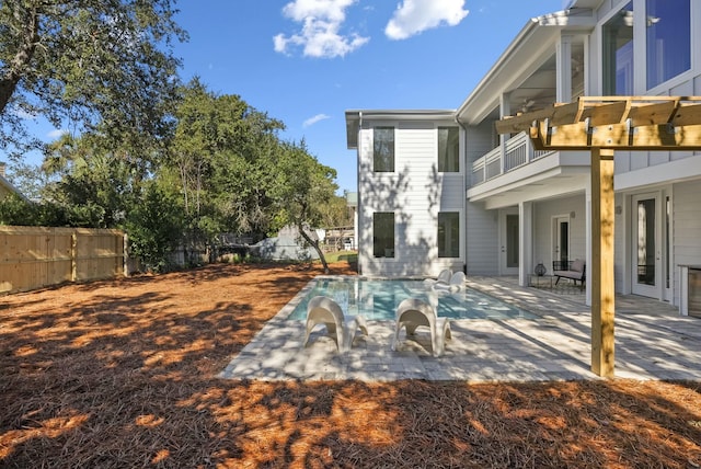 exterior space with a balcony, a patio area, and a fenced in pool