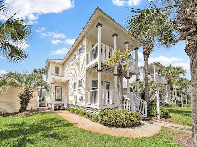 coastal home featuring a porch and a front lawn