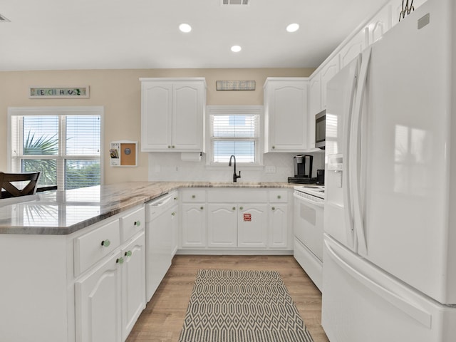 kitchen with white cabinets, white appliances, and sink