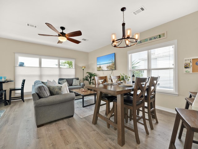 dining room featuring plenty of natural light, light hardwood / wood-style floors, and ceiling fan with notable chandelier