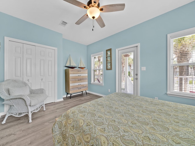 bedroom with hardwood / wood-style floors, ceiling fan, access to exterior, and a closet