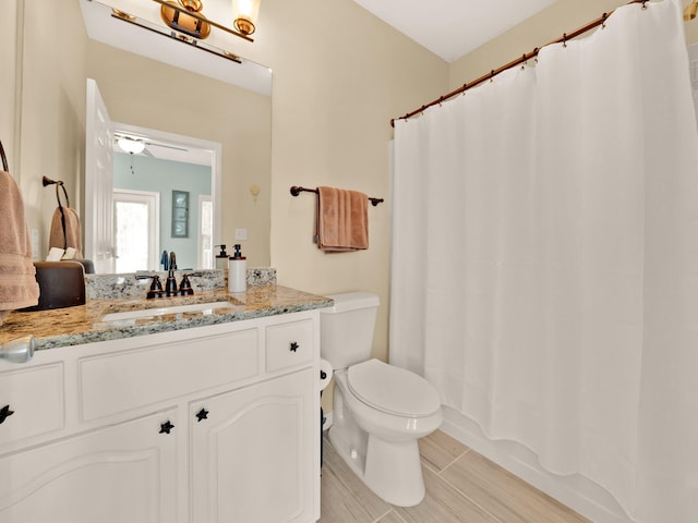 bathroom featuring vanity, ceiling fan, and toilet