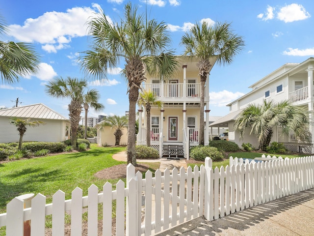 view of front of house featuring a balcony and a front yard