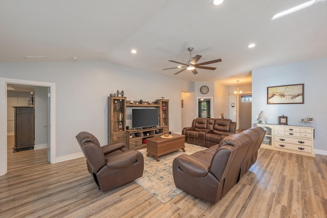 living room with ceiling fan with notable chandelier, vaulted ceiling, and light hardwood / wood-style flooring