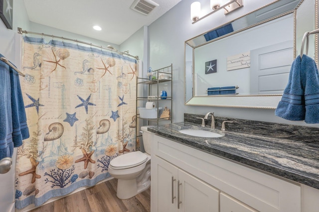 bathroom featuring a shower with curtain, hardwood / wood-style floors, vanity, and toilet