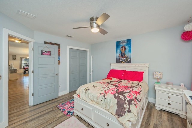 bedroom with ceiling fan, a closet, and dark hardwood / wood-style floors