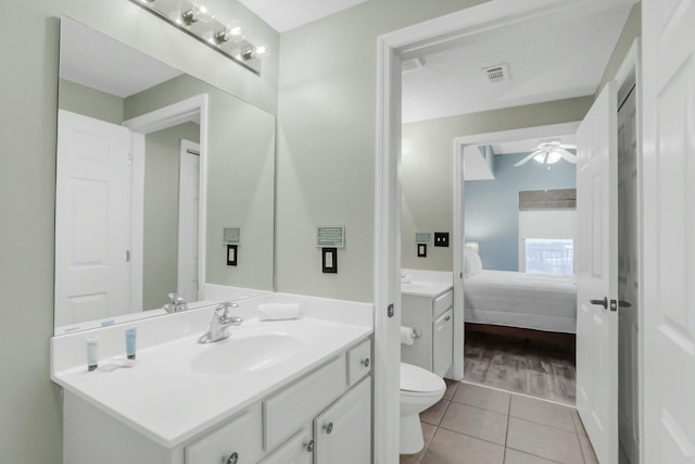 bathroom with tile patterned flooring, vanity, ceiling fan, and toilet