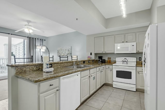 kitchen featuring sink, light tile patterned floors, kitchen peninsula, white appliances, and white cabinets