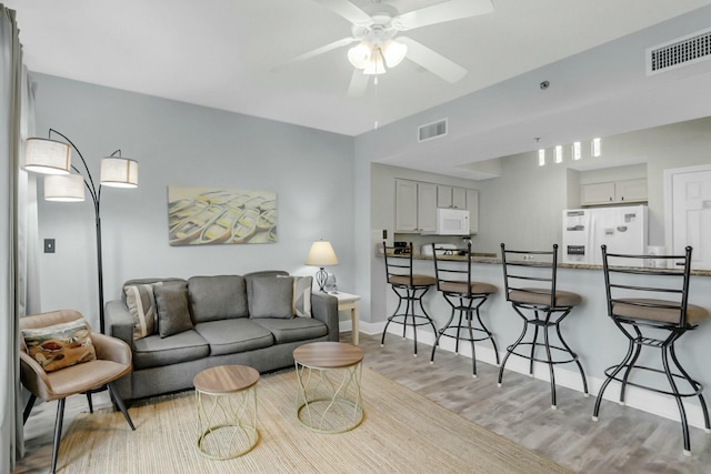 living room with ceiling fan and light wood-type flooring