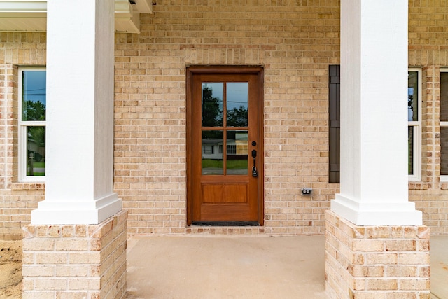 doorway to property with brick siding