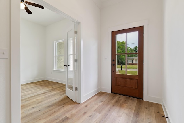 entryway with plenty of natural light, light wood-style flooring, and baseboards