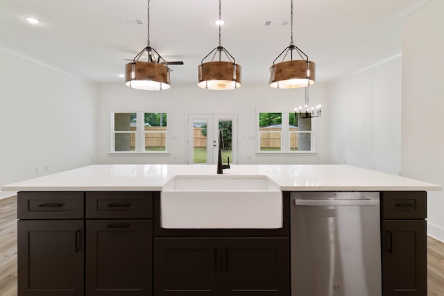 kitchen featuring hanging light fixtures, light countertops, crown molding, stainless steel dishwasher, and a sink