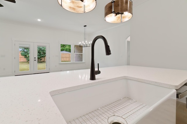 room details featuring recessed lighting, a sink, french doors, light stone countertops, and decorative light fixtures