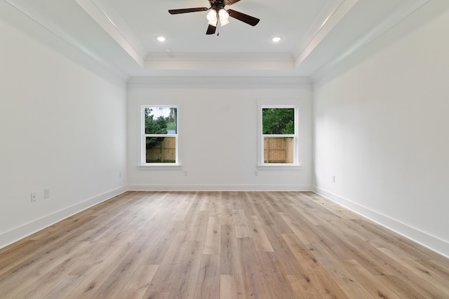 unfurnished room with a tray ceiling, a healthy amount of sunlight, and baseboards