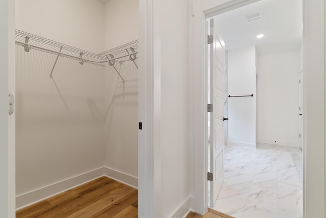 spacious closet with marble finish floor and visible vents