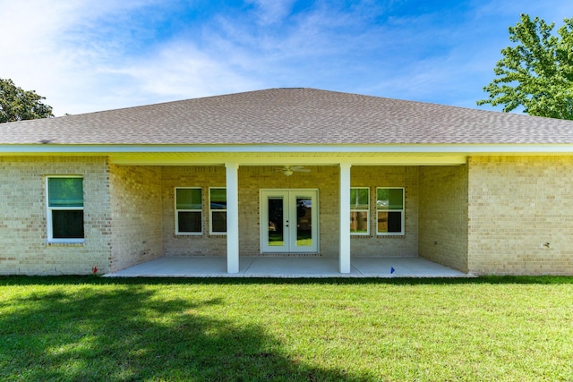 rear view of property featuring brick siding, french doors, a lawn, roof with shingles, and a patio area