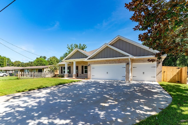 craftsman house with brick siding, fence, driveway, a front lawn, and board and batten siding