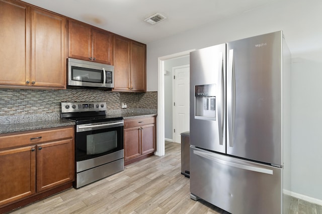 kitchen featuring appliances with stainless steel finishes, tasteful backsplash, and light hardwood / wood-style floors