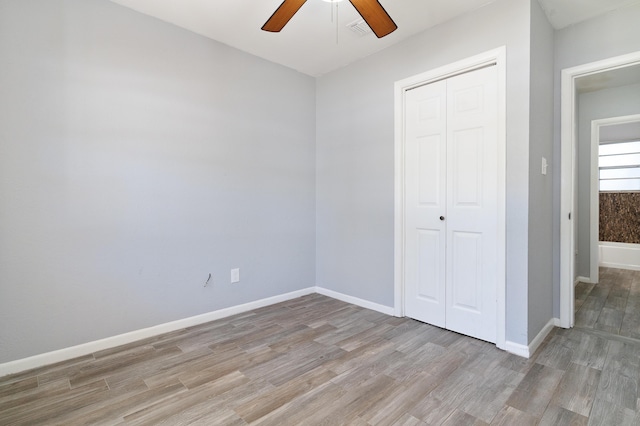 unfurnished bedroom with a closet, light hardwood / wood-style flooring, and ceiling fan